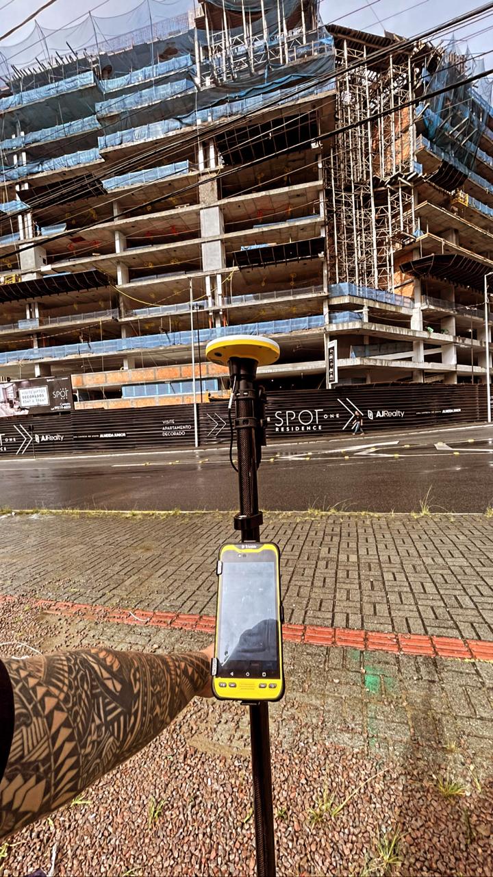 Receptor GNSS da Siemann diante de edifício em construção